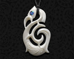 Close-up of an intricately carved Manaia pendant