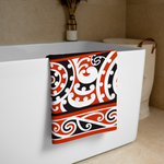White bathtub with a Maori towel featuring red, black, and white Kōwhaiwhai patterns.