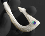 Hand carved Maori bone Hei Matau fish hook necklace held between fingers to show size