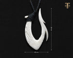 Hand-carved bone Hawaiian Makau fish hook necklace showing measurements on a plain black background