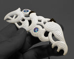Large 115mm Māori necklace pendant measured with digital calipers to show the 11.5cm scale of the hand-carved bone Manaia.