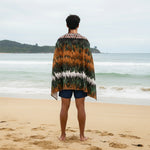 Man standing on a beach with a Māori feather cloak Beach Towel