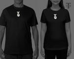 Scale reference graphic showing the white carved bone whale tail fish hook pendant worn as a necklace on male and female model mockups against black t-shirts.