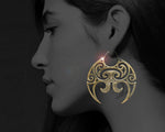 Model showcasing large brass Moko Kauae inspired earrings - Tuwharetoa Bone cultural jewelry