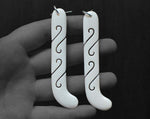 Close-up of hand-carved bone kapeu earrings