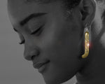 Brass Kapeu Maori Earrings being worn, demonstrating their size and style as traditional New Zealand ear pendants