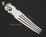 Bone hair comb with a contemporary Maori manaia design and iridescent paua shell, showcasing New Zealand artistry