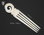 Bone hair comb featuring a Maori koru symbol and iridescent paua shell inlay, reflecting New Zealand artistic heritage